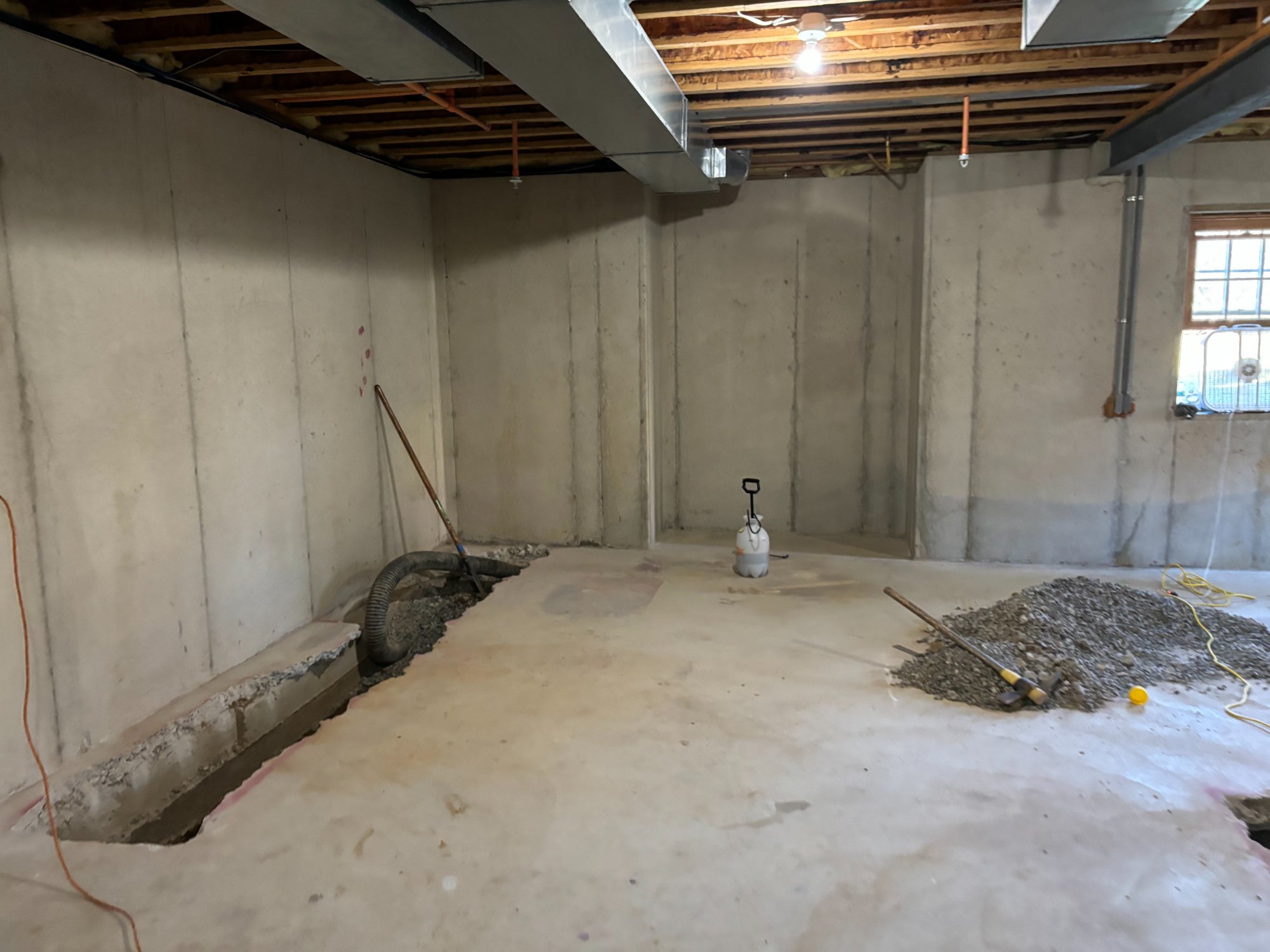 Interior french drain trench opened along the foundation perimeter prior to waterproofing installation