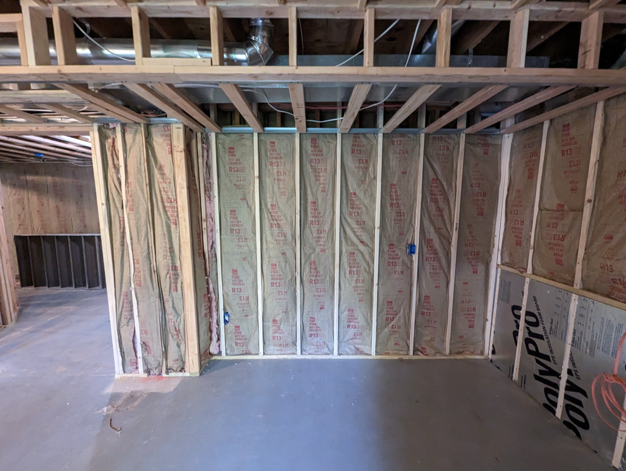 R-13 faced fiberglass batt insulation fully installed in exterior basement wall cavities