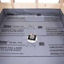 Old vinyl PVC shower pan liner with drain installed over mortar pre-slope — the traditional wet bed waterproofing method