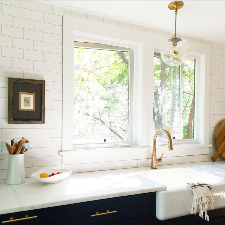 Brass fixtures with navy blue cabinets