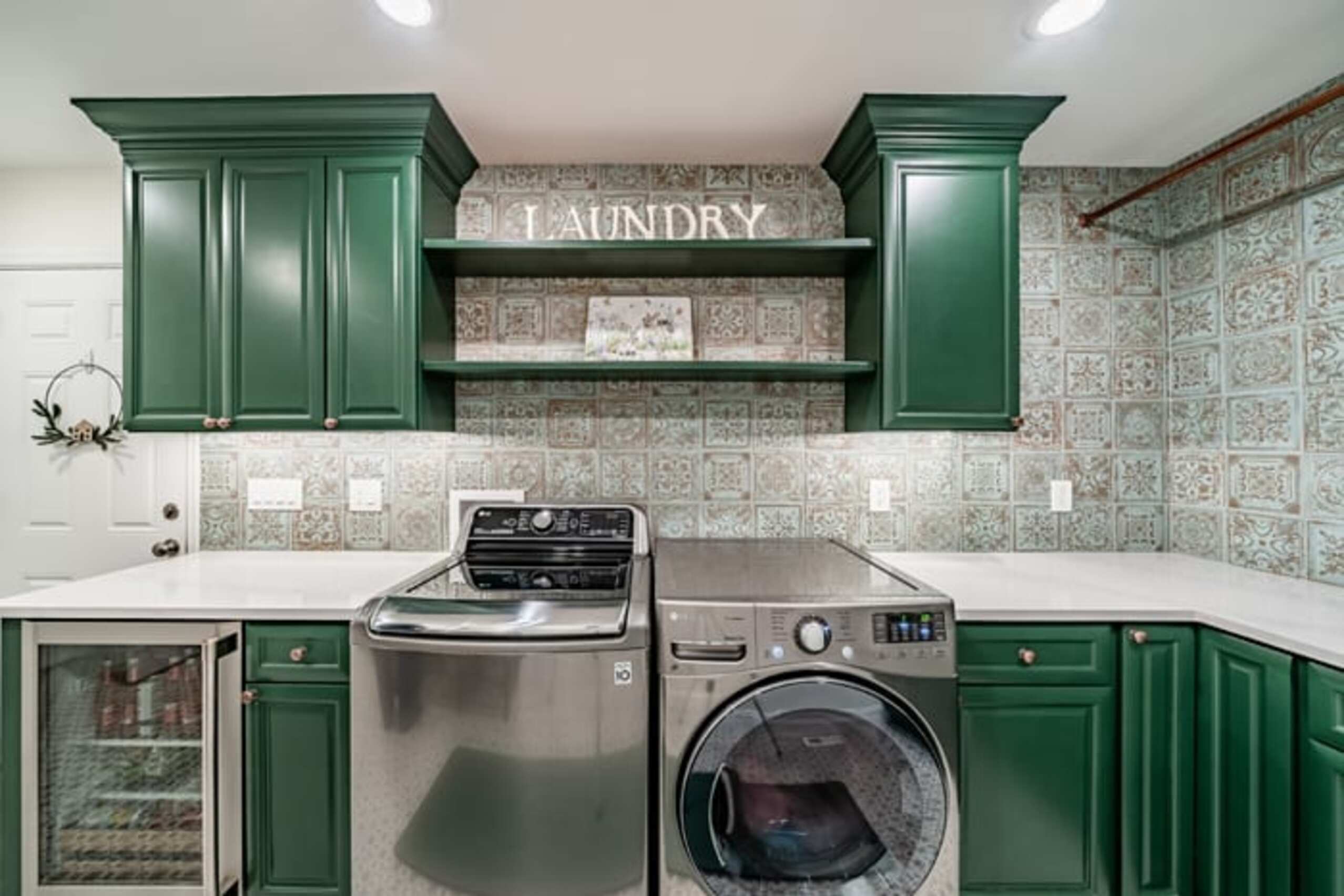 Chadds Ford laundry room with emerald green custom cabinetry and decorative tile