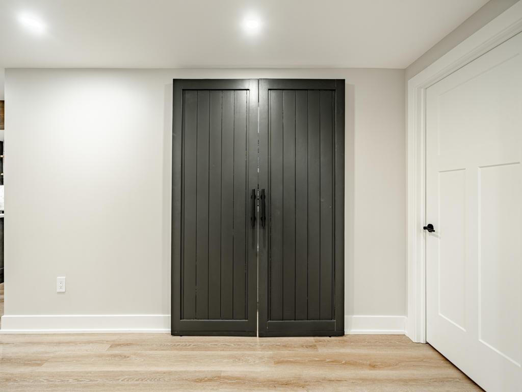 Closed view of custom dark shiplap pantry doors with invisible Houdini-style touch-latch hardware in Chester Springs basement remodel
