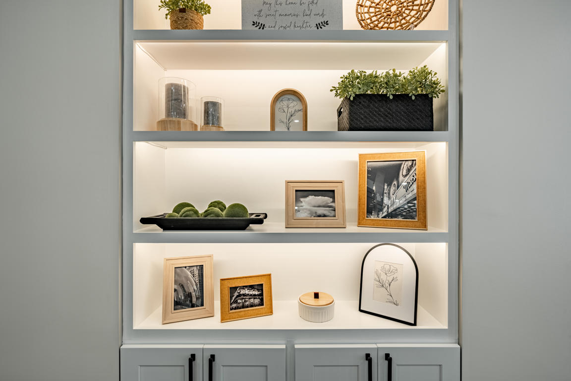 Custom wood-banded range hood with white painted body, natural oak accent band, and crown molding detail above induction cooktop