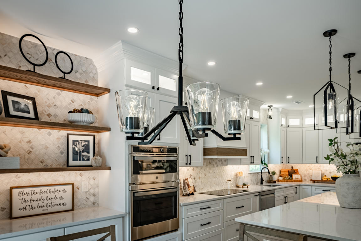 Arabesque marble mosaic backsplash detail showing diamond pattern in white, gray, and warm taupe tones with under-cabinet lighting