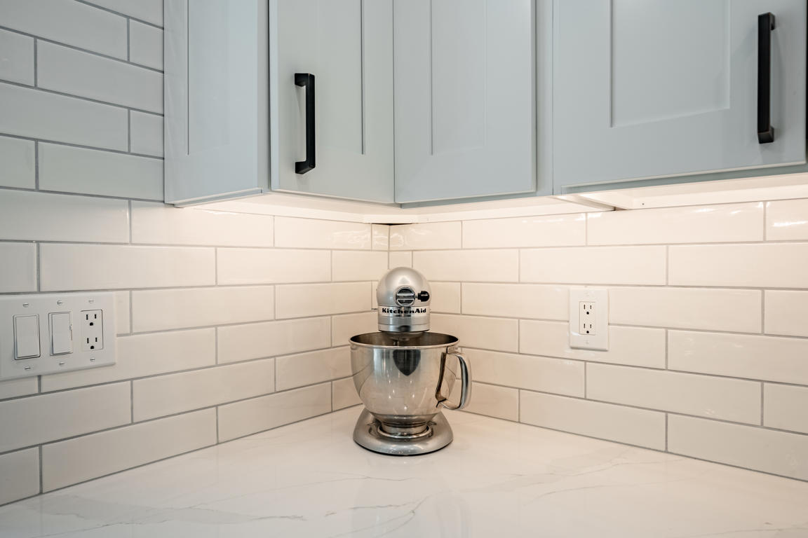 White subway tile backsplash detail with KitchenAid mixer on quartz countertop