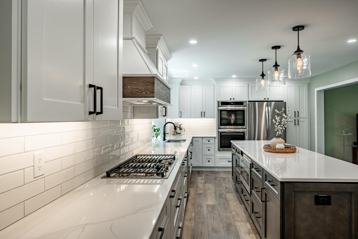 Gas cooktop area with quartz countertops and custom range hood