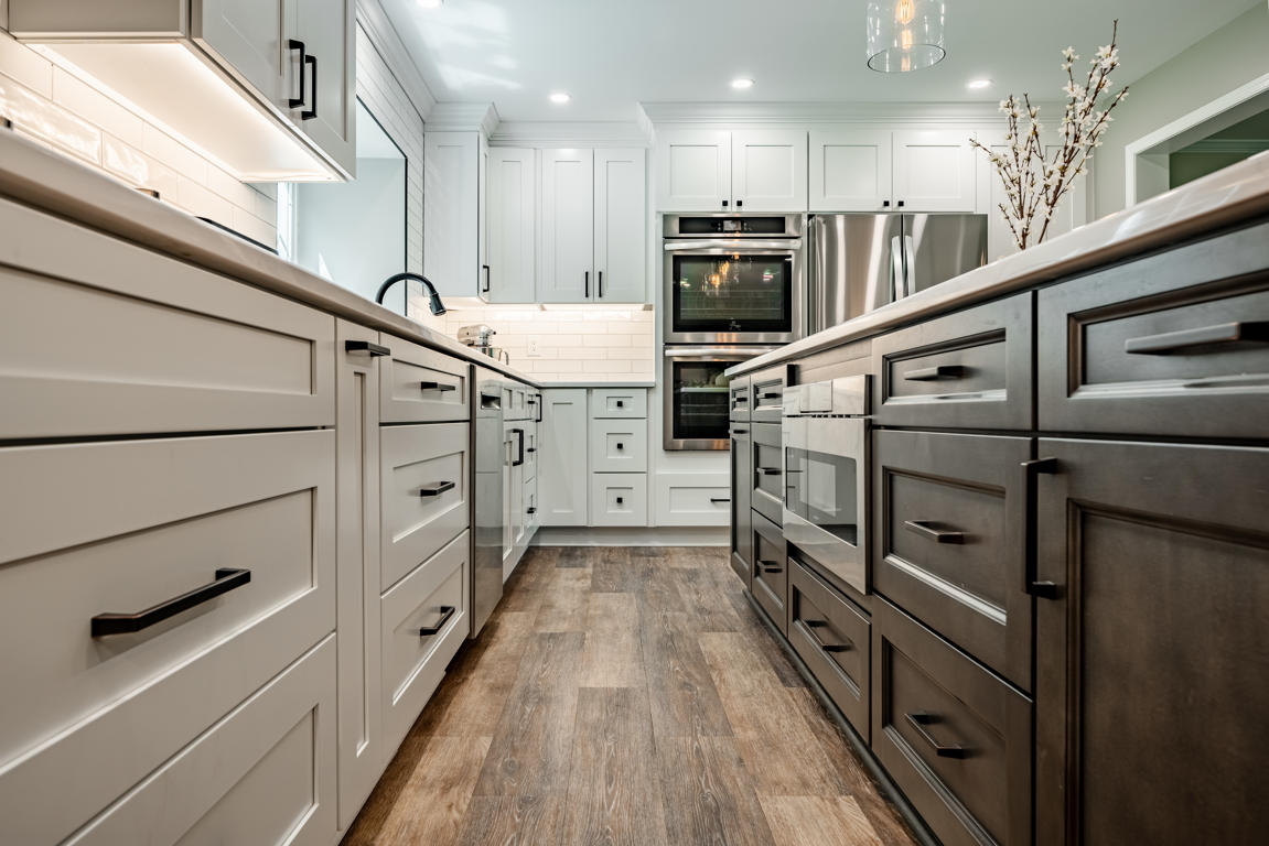 Kitchen island and perimeter cabinet detail showing two-tone cabinetry with matte black hardware