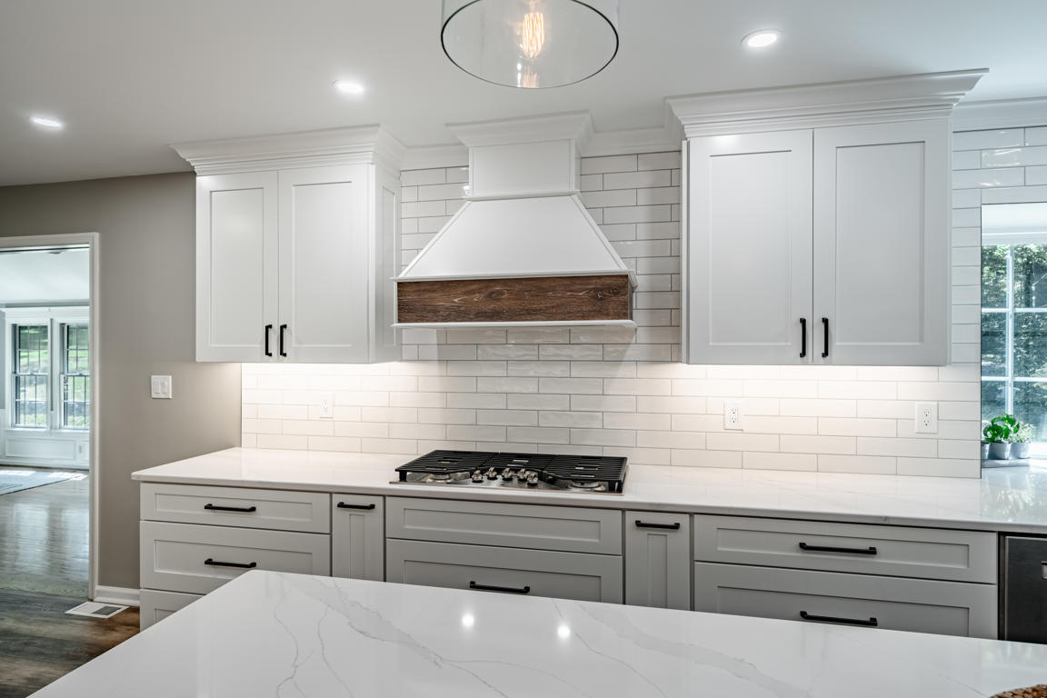 Range hood with reclaimed barnwood and glossy subway tile extending to ceiling