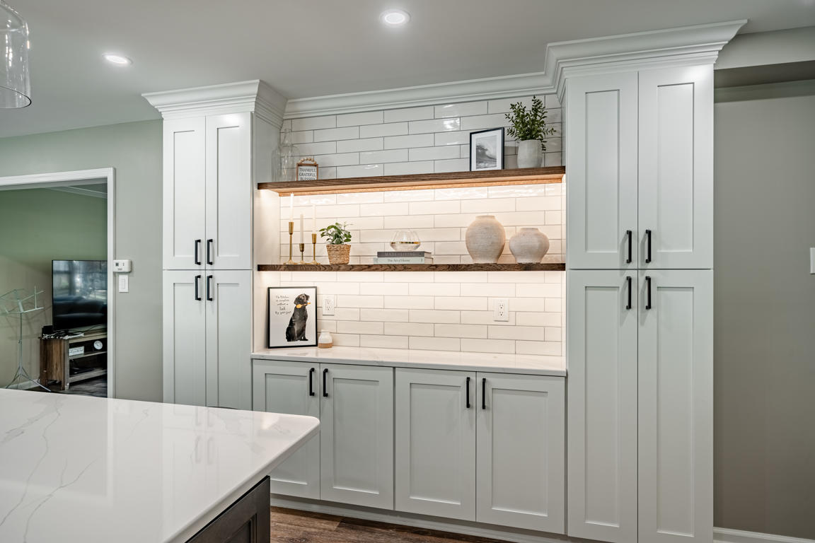 Built-in kitchen display niche with rustic floating wood shelves, LED under-cabinet lighting, and subway tile backsplash