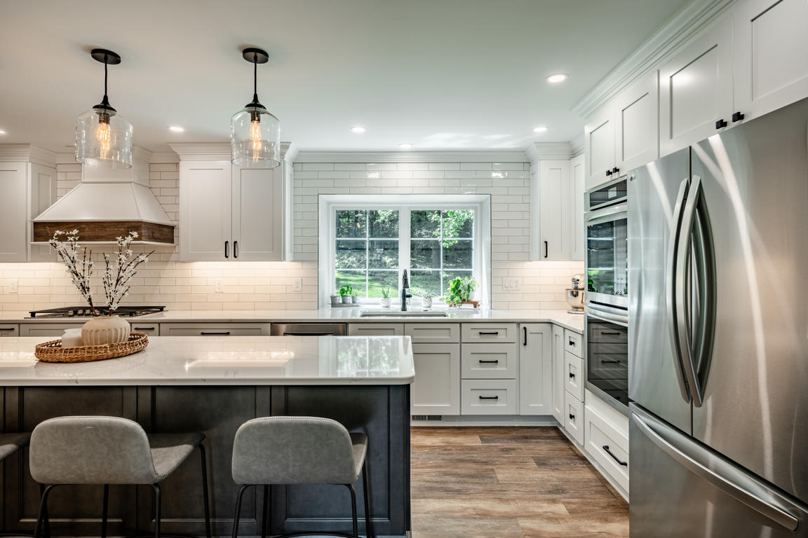 Kitchen island from bar stool perspective showing quartz countertop and pendant lights