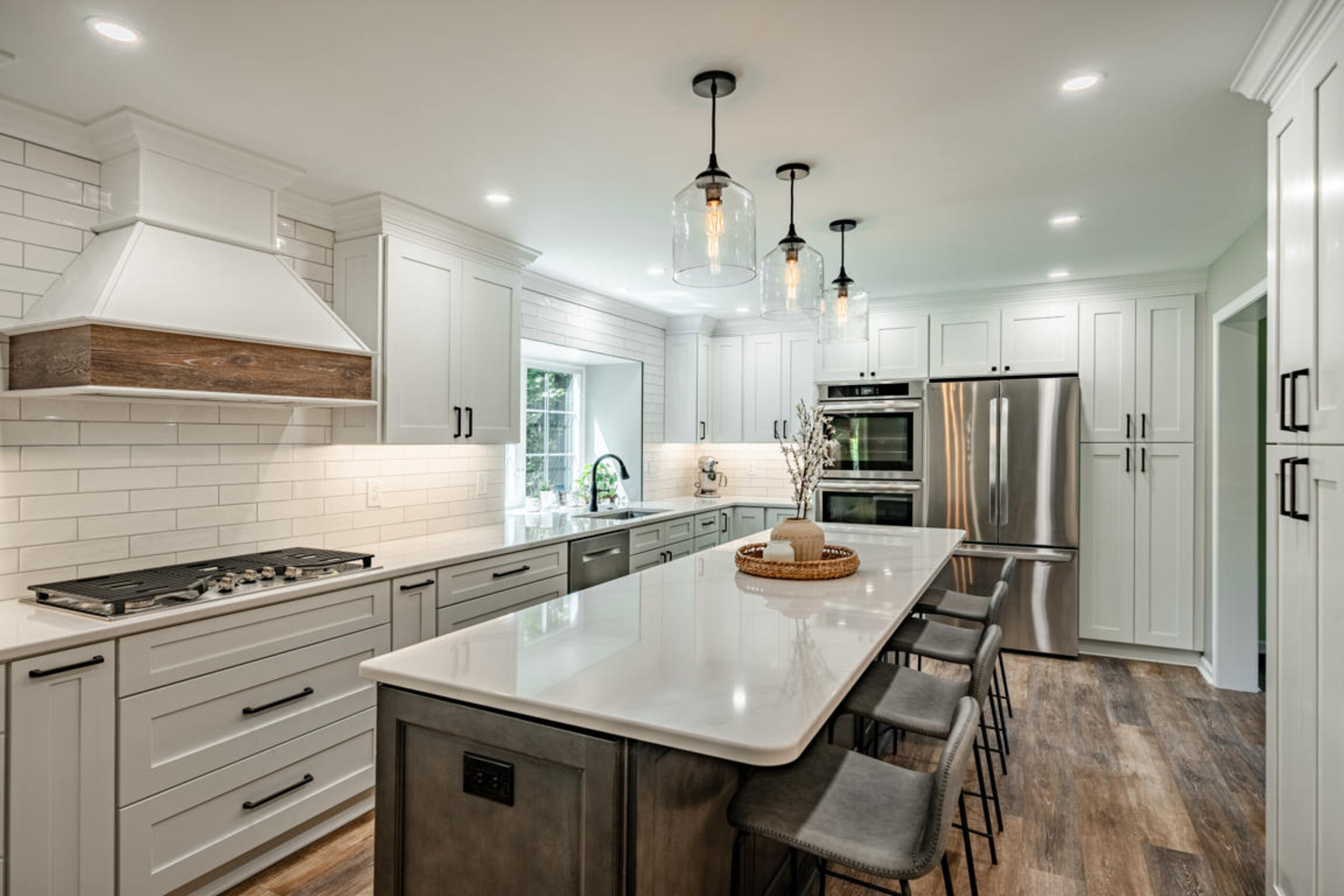 Exton PA kitchen remodel with white shaker cabinets, dark walnut island, quartz countertops, and glass pendant lights