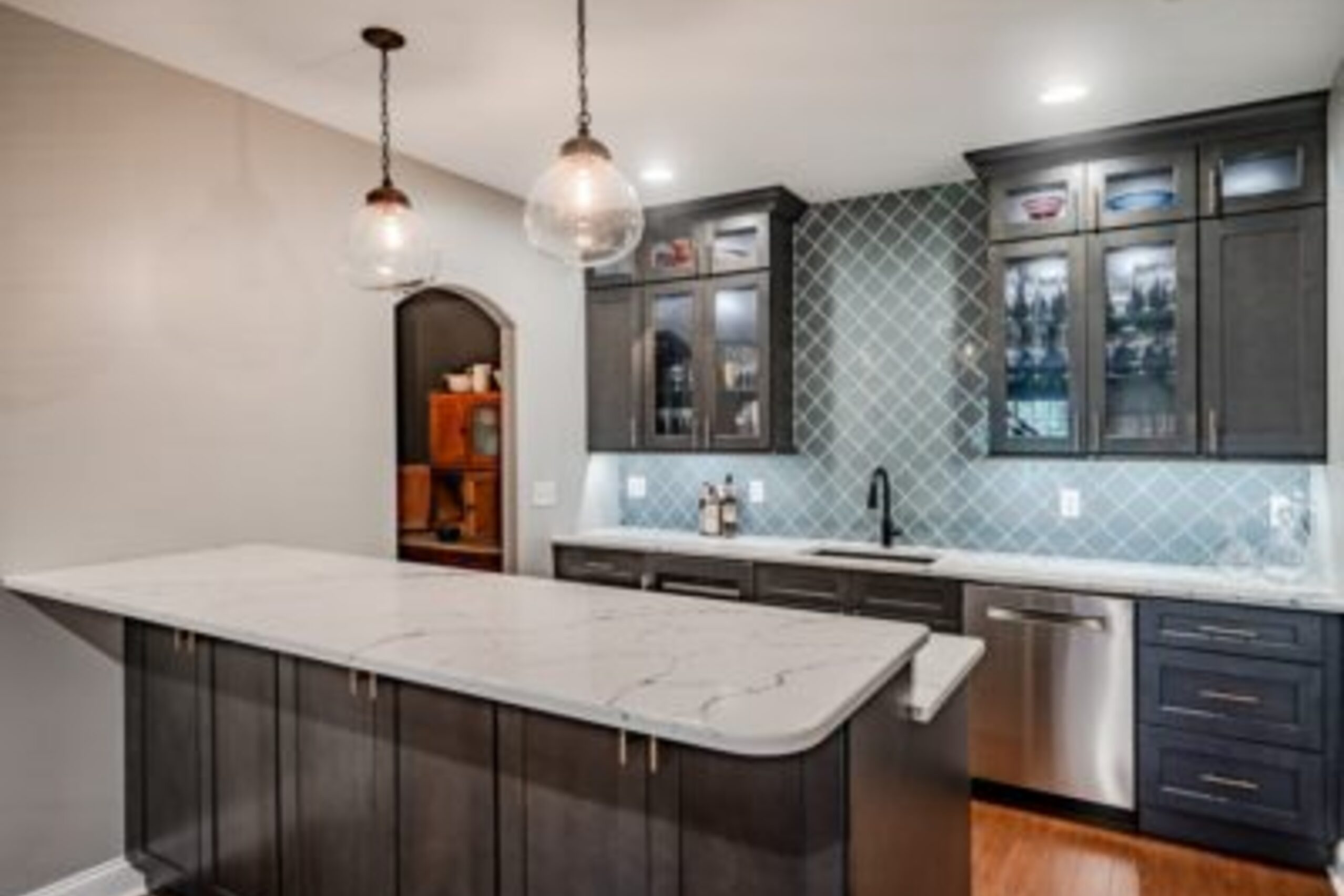 Glenmoore wine room with built-in wine rack, glass-front cabinets, and custom bar seating