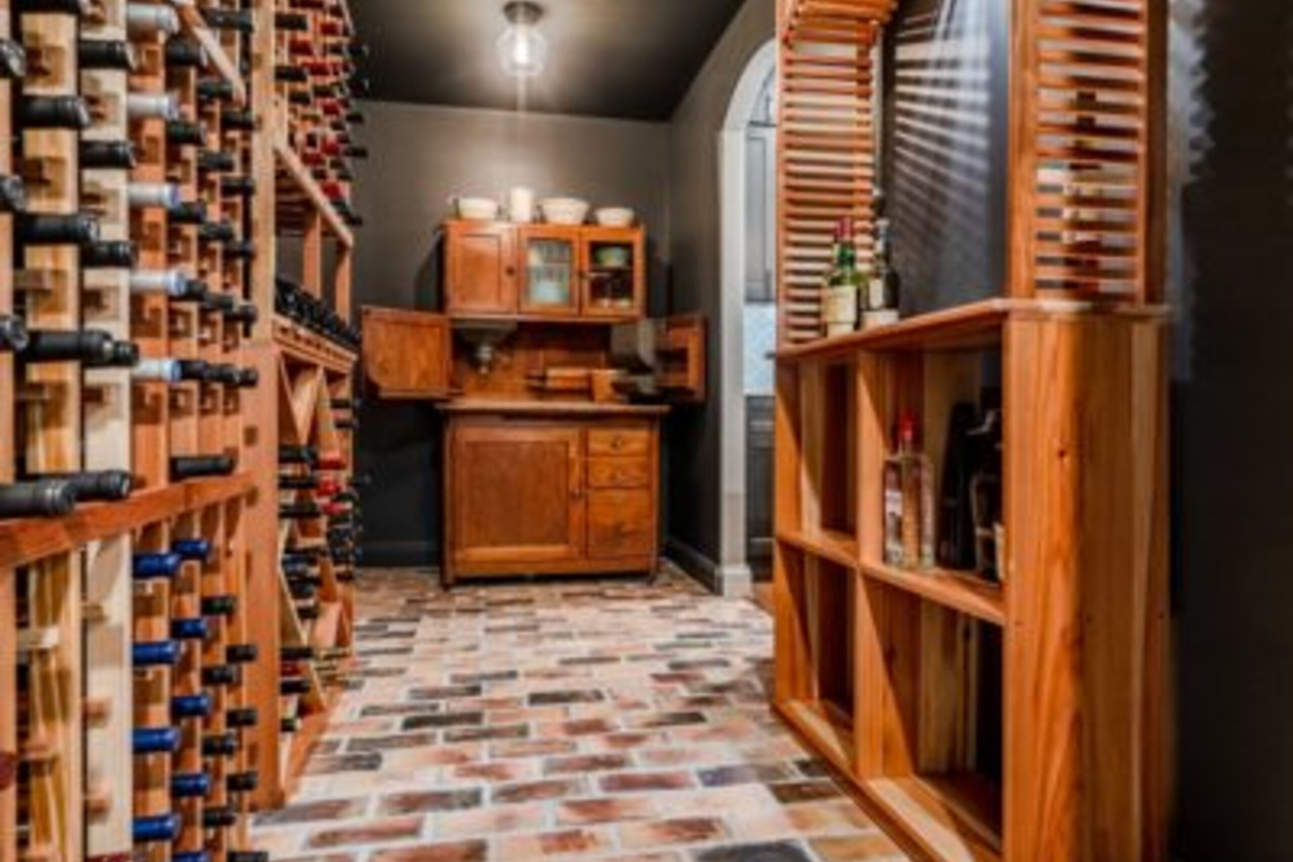 Glenmoore bar with white cabinetry, wine glass storage, diamond tile backsplash, and floating shelves
