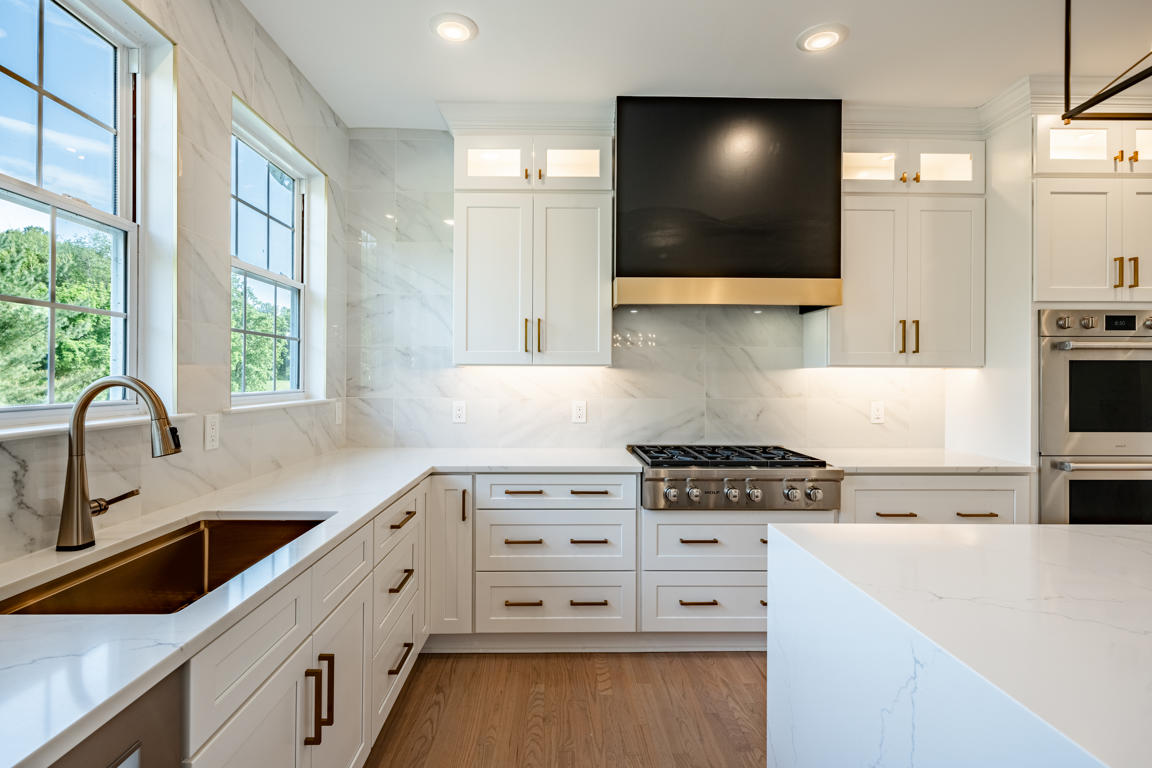 Kitchen layout overview showing island with waterfall edges, perimeter cabinets, range hood wall, and open dining area