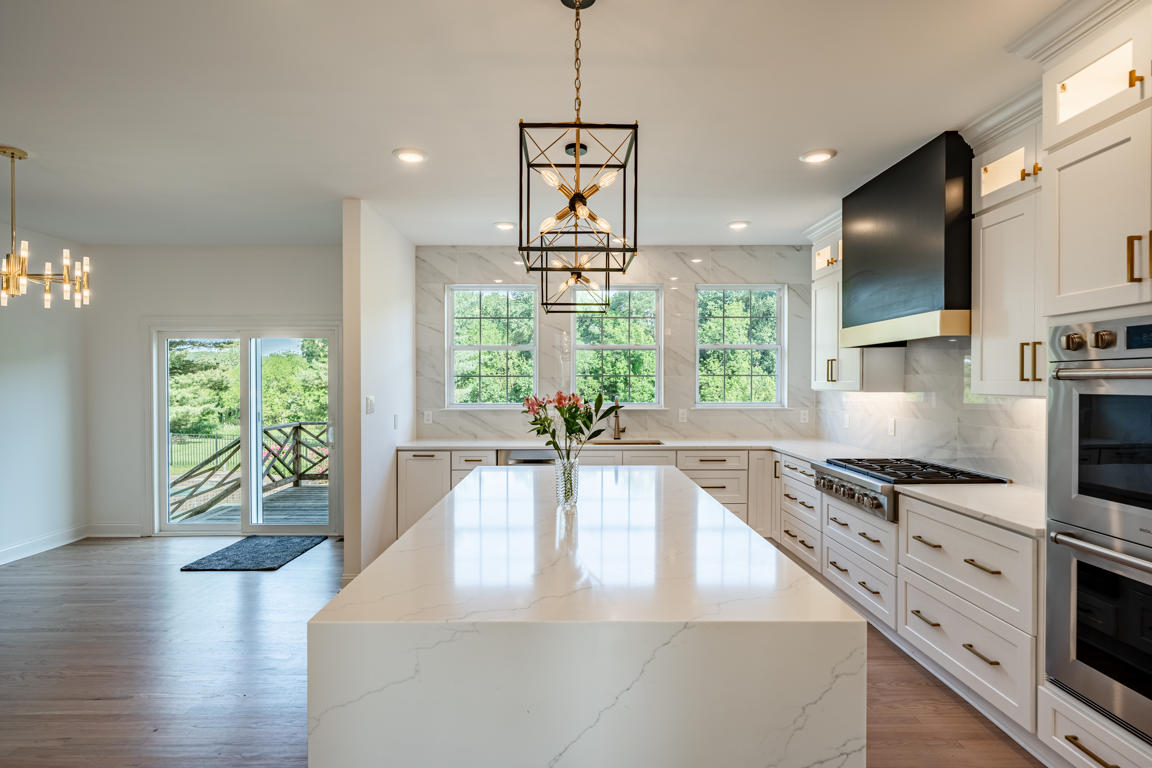 Under-cabinet lighting illuminating marble-look porcelain backsplash and quartz countertop work surface