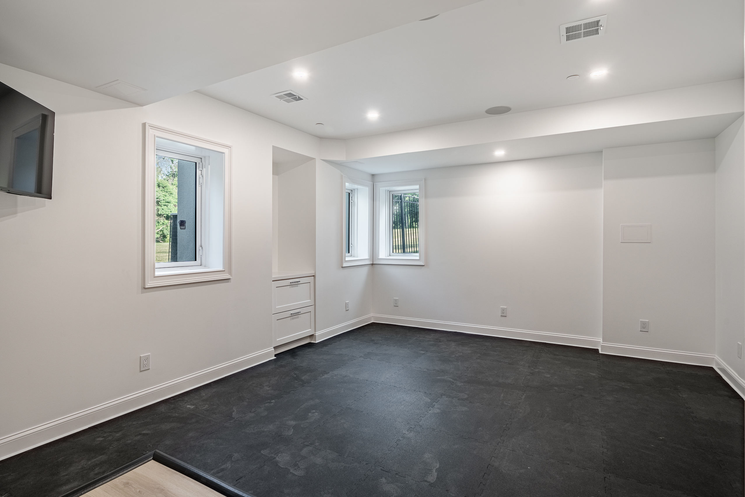 Newtown Square basement gym room - rubber flooring with recessed lighting and built-in drawers
