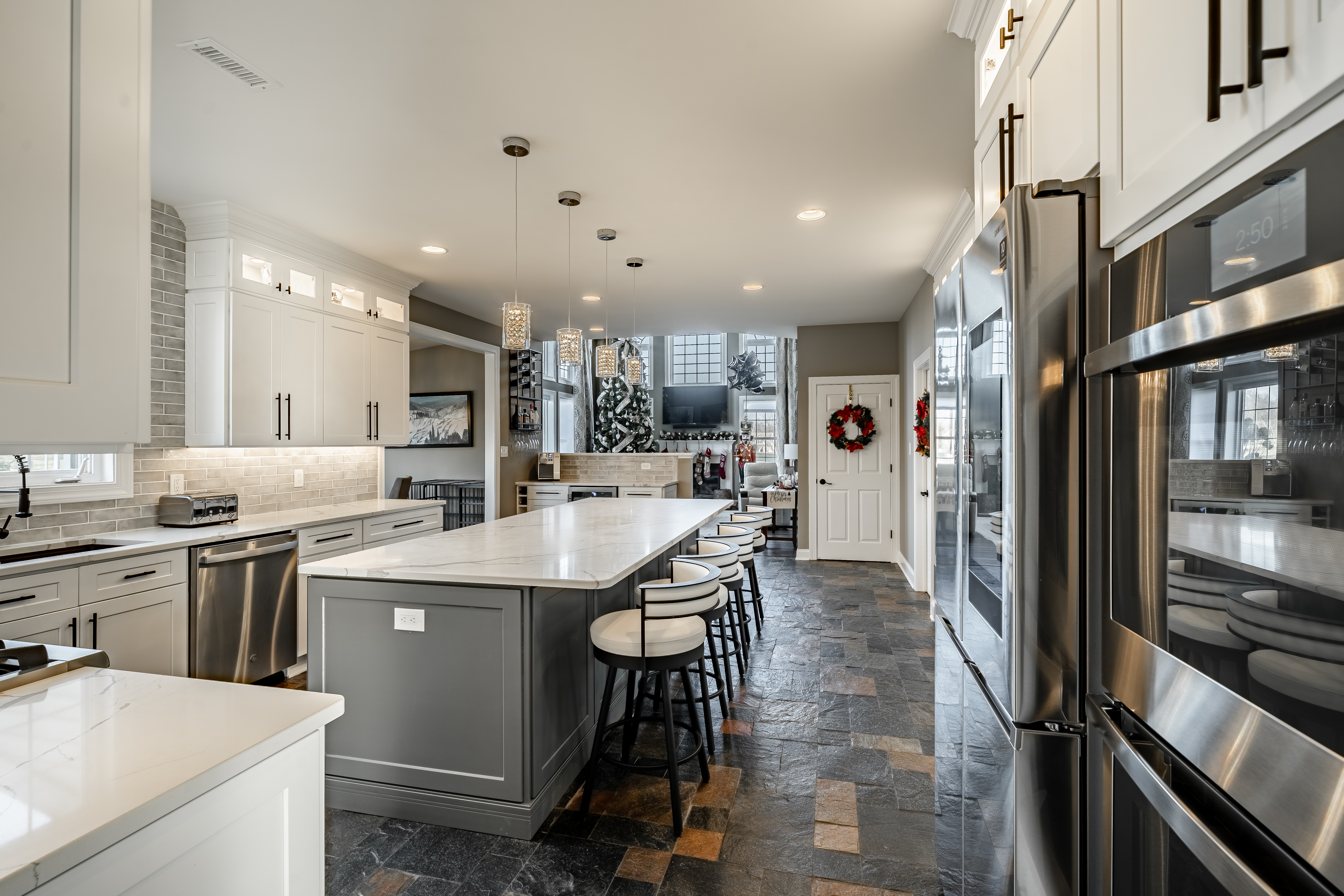 West Brandywine kitchen remodel - long view showing island with bar seating, stainless appliances, and open concept flow to living area