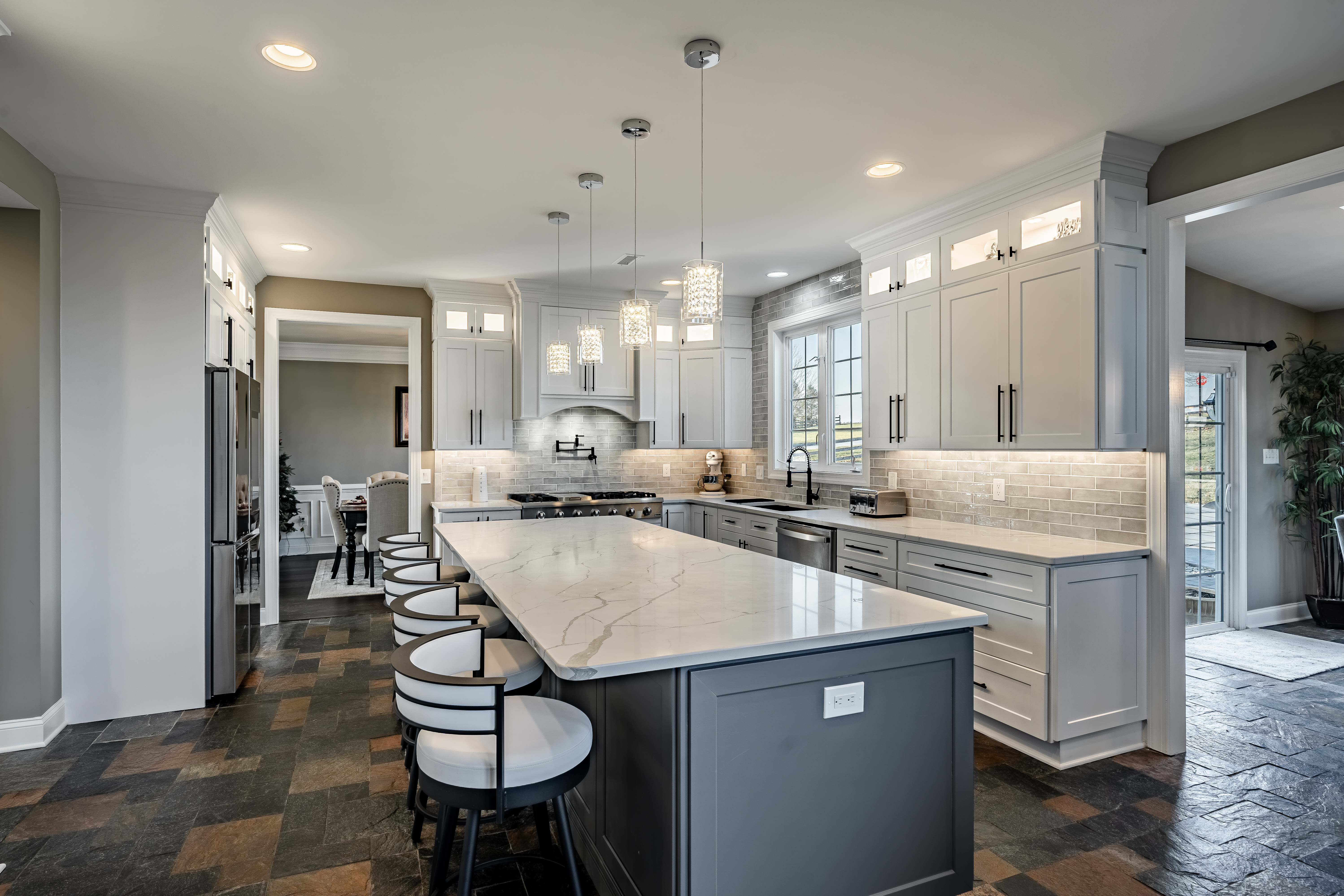 West Brandywine kitchen renovation - island with bar stools, pendant lighting, and glazed tile backsplash behind gas range