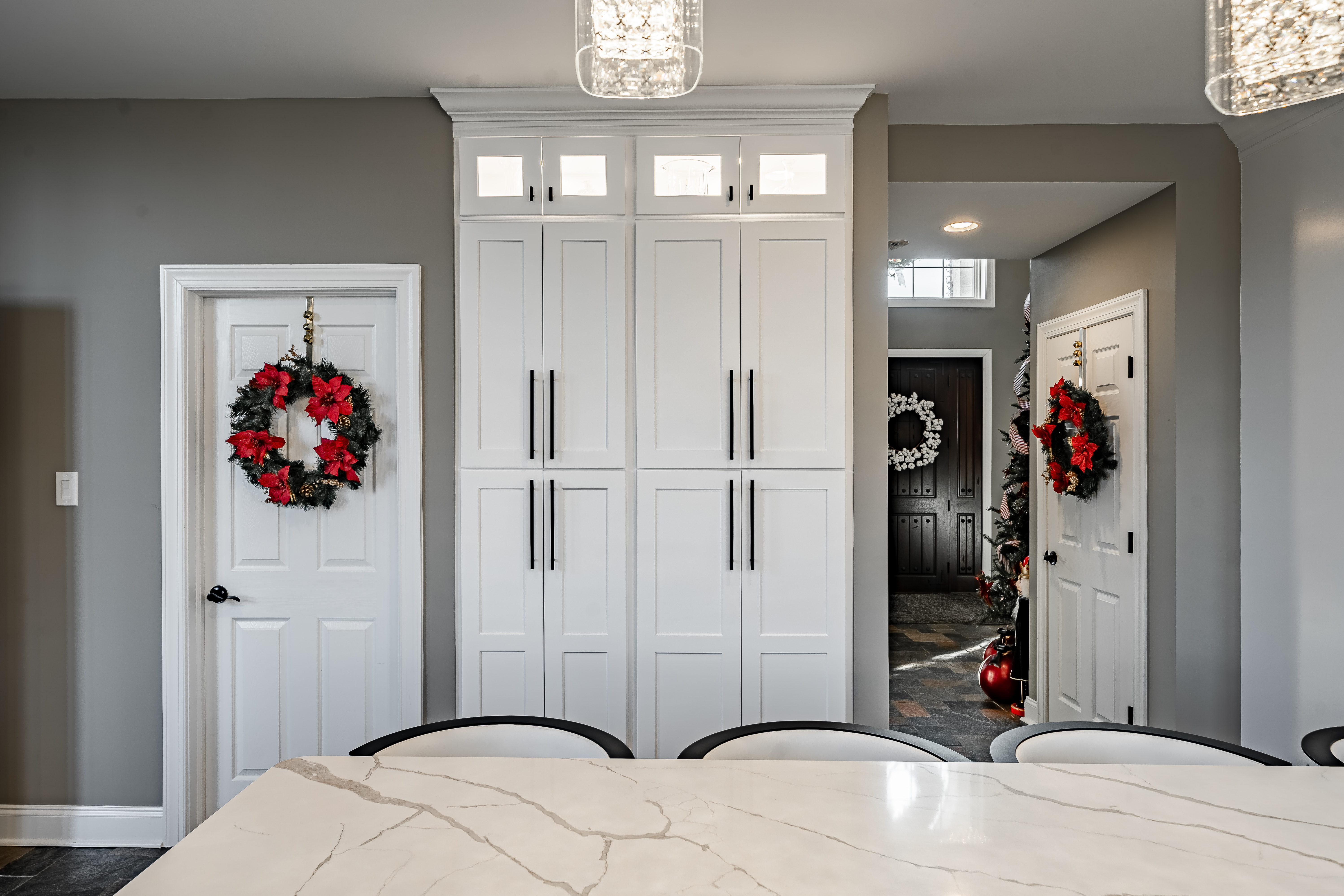 West Brandywine kitchen - floor-to-ceiling pantry with matte black hardware, crystal pendant lights over island, quartz countertop detail