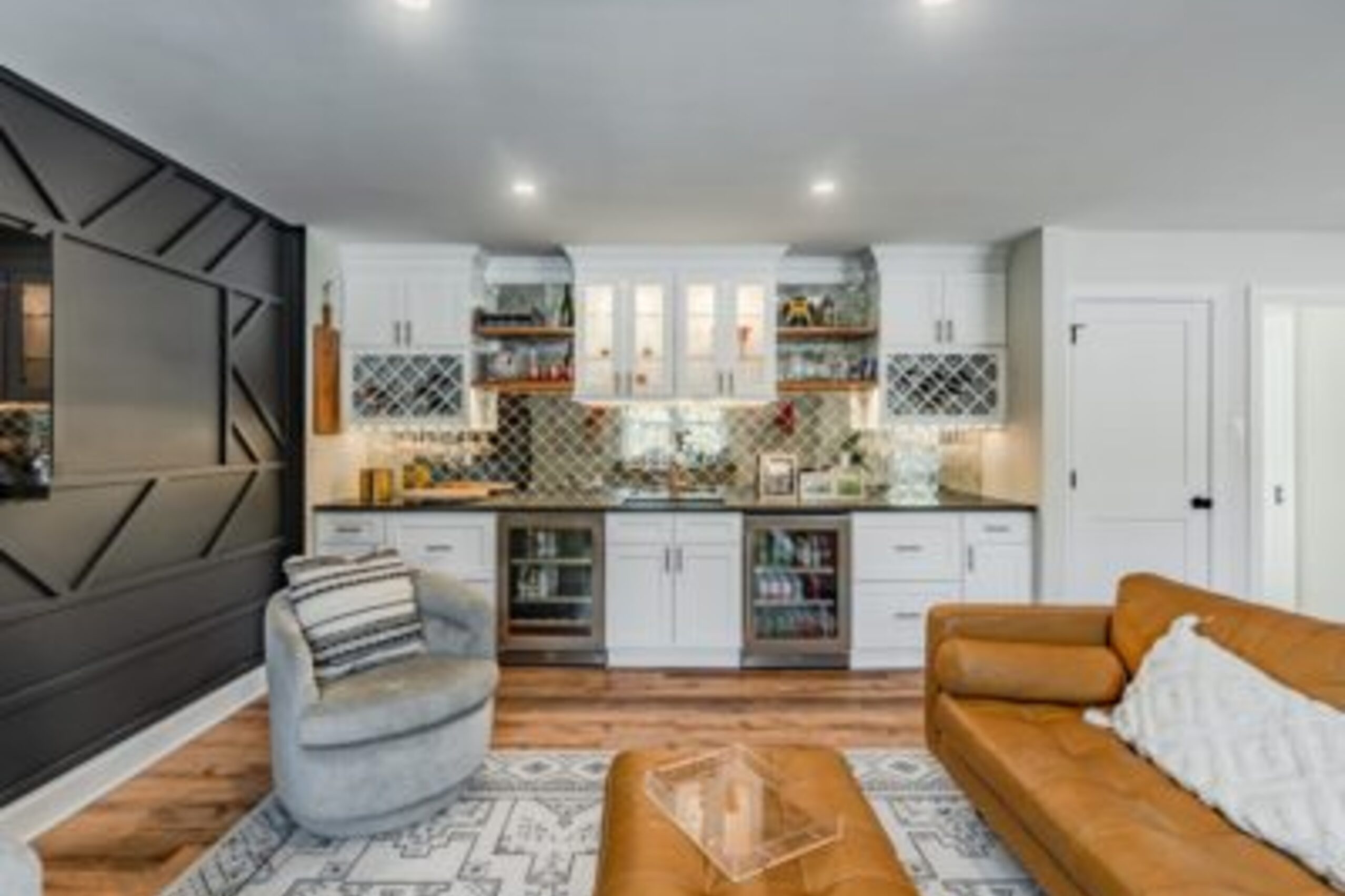 West Chester living room with wet bar, diamond mirror backsplash, black accent wall, and leather seating