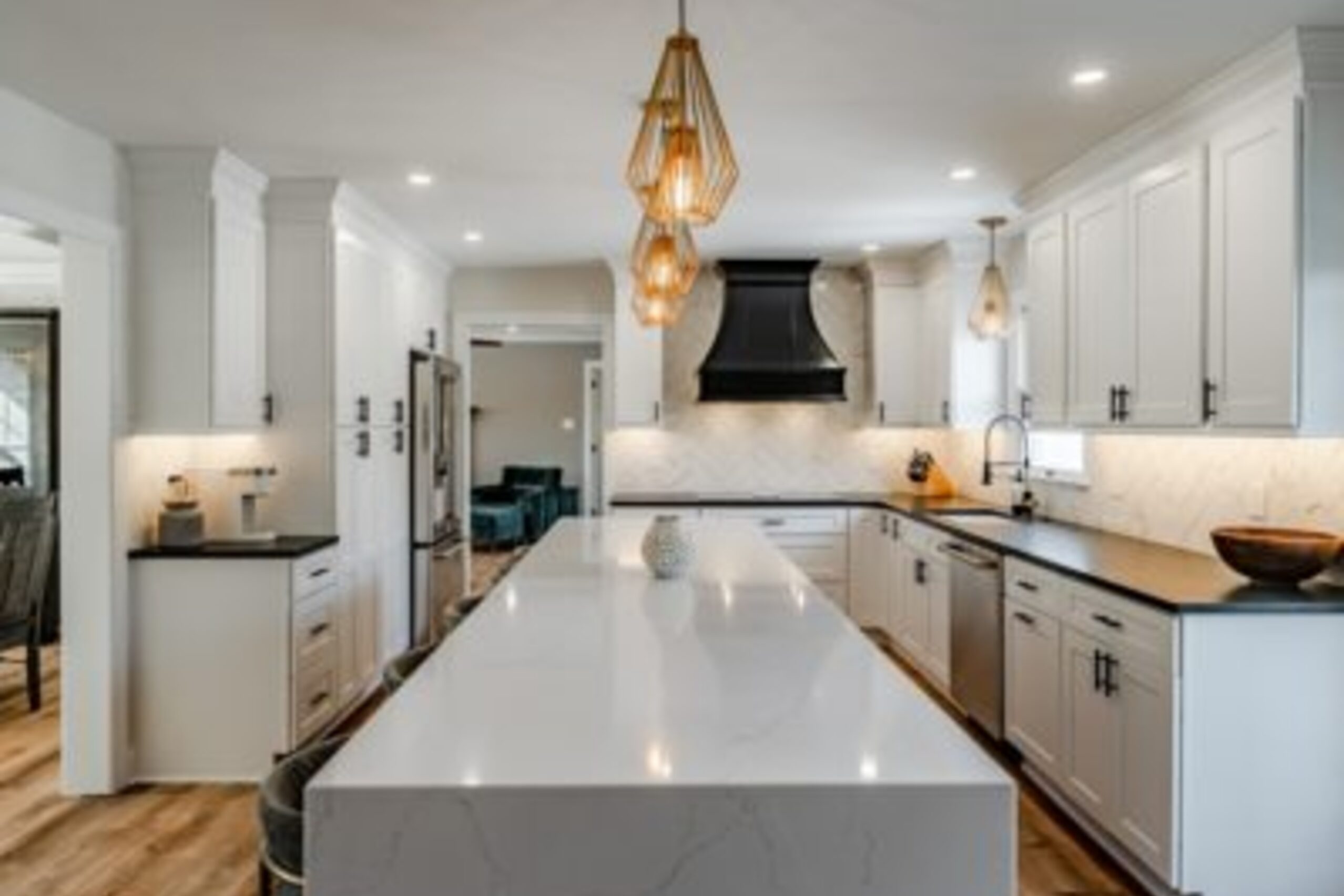 West Chester kitchen remodel with white cabinets, quartz island, gold teardrop pendants, and black range hood