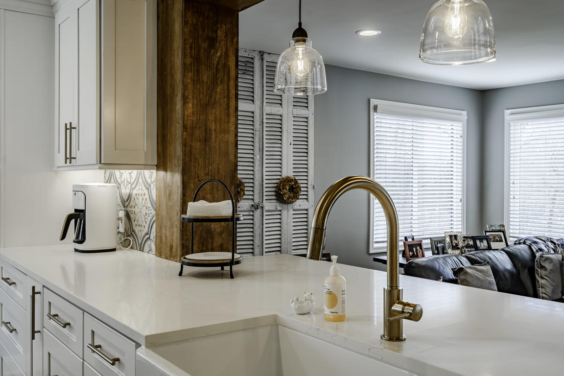 Quartz countertop detail on peninsula showing subtle veining pattern and waterfall edge against white cabinetry