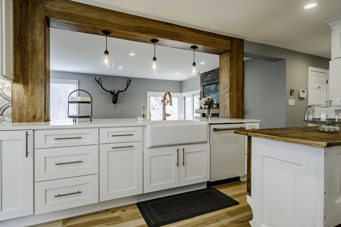 Gas range cooktop detail with stainless steel grates, brass control knobs, and cement tile surround