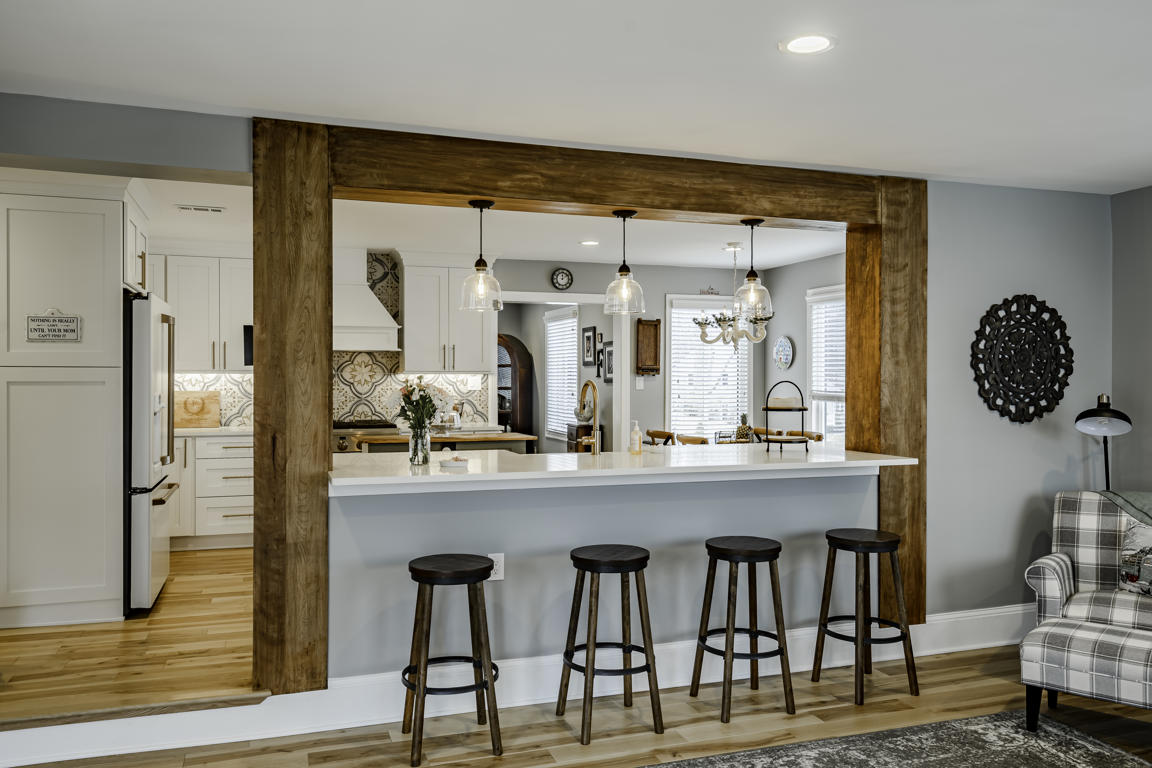 Kitchen appliance wall with stainless refrigerator, wall oven, and surrounding white pantry cabinetry