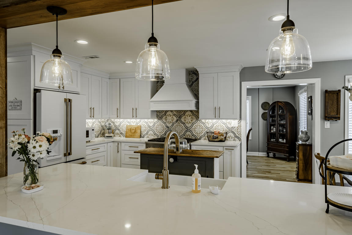 Wide view of family room and kitchen peninsula connection with exposed wood structural beam dividing spaces