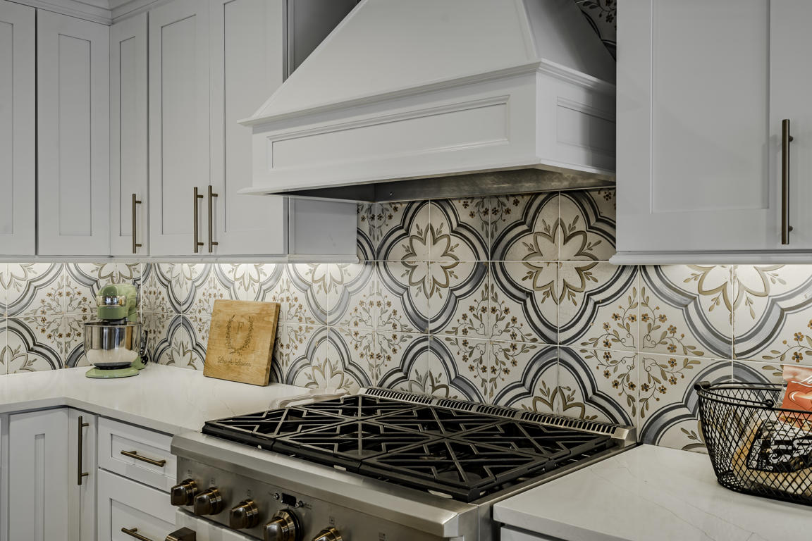 Farmhouse kitchen open layout with pendant lights over peninsula, recessed ceiling lights, and hickory hardwood flooring