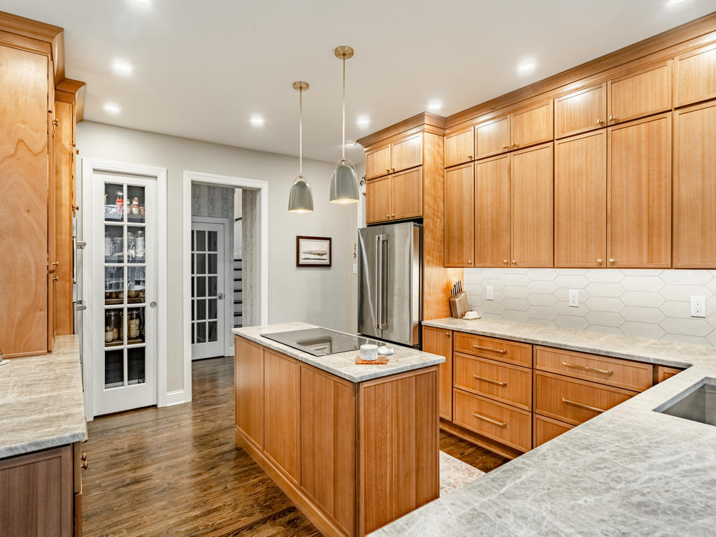 West Chester kitchen maple shaker cabinetry with brushed bronze hardware, leathered quartzite countertops, and custom 8-ft French door pantry entry