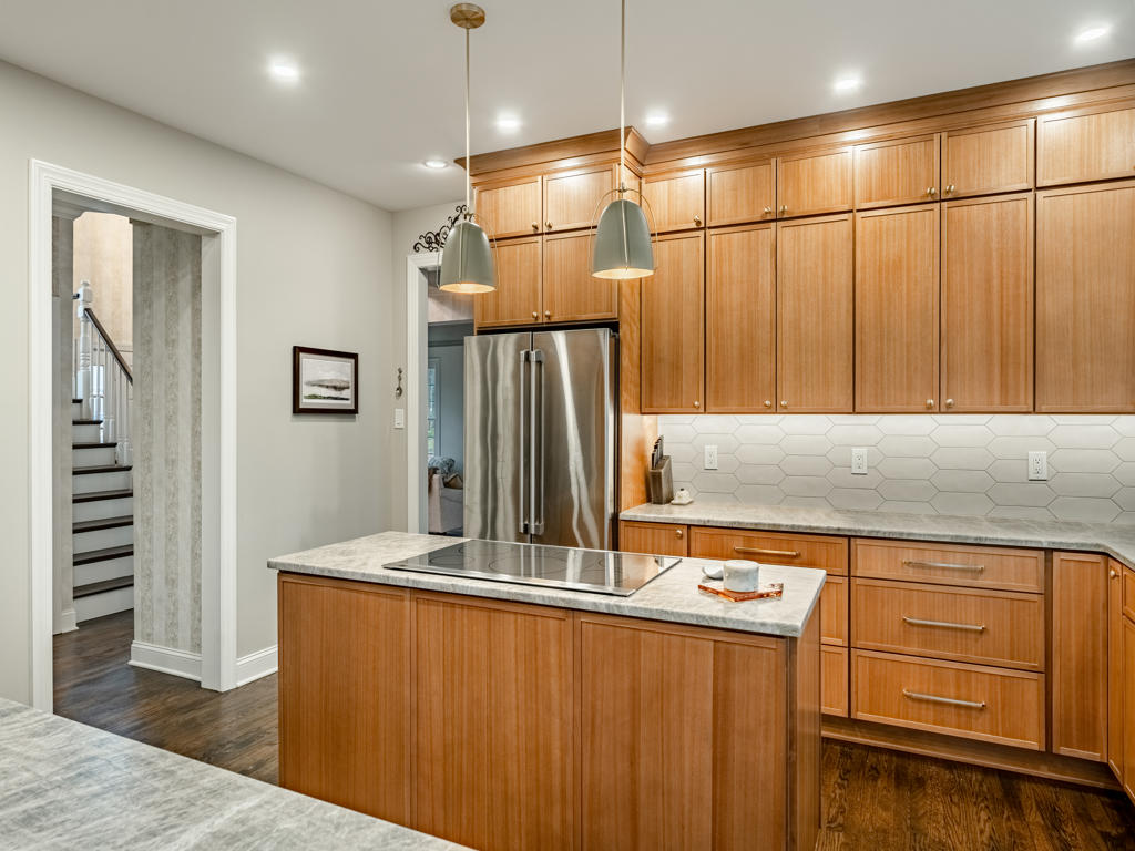 Light maple petite shaker cabinets running to ceiling height with crown molding, dome pendant lights, and French door pantry visible in West Chester kitchen