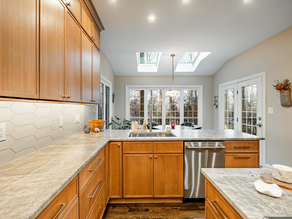 West Chester kitchen perimeter countertops in leathered quartzite with sink, stainless dishwasher, picket tile backsplash, and French doors to nook beyond
