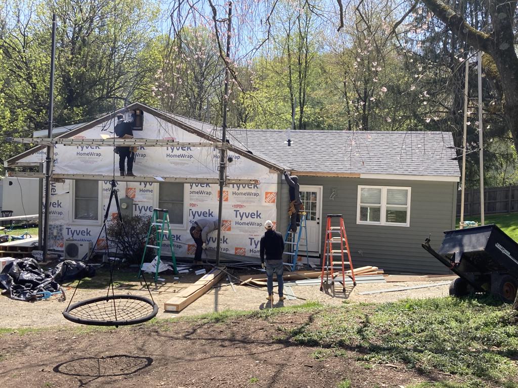 Crew installing fiber cement siding with Tyvek house wrap
