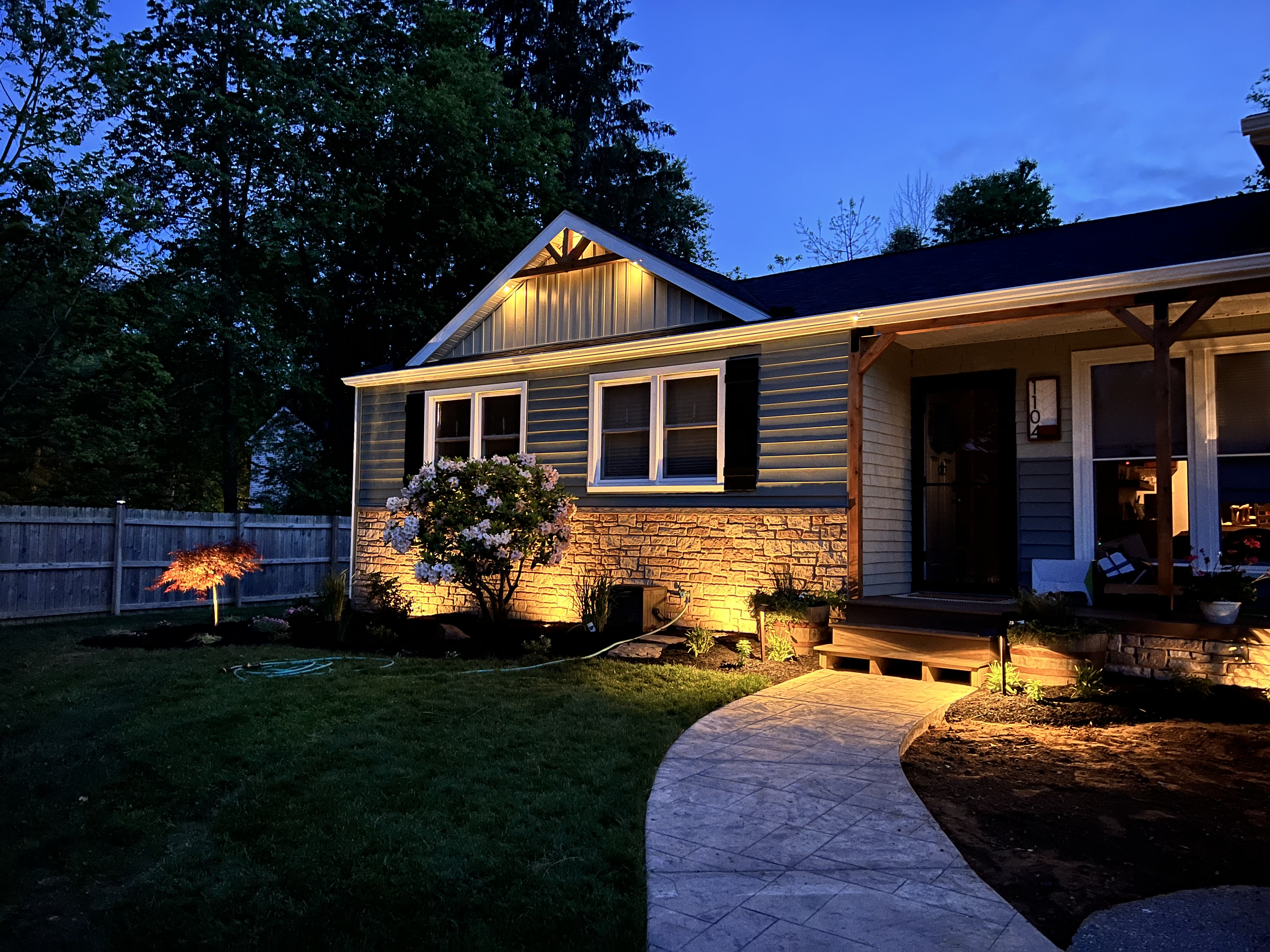 Home at dusk with landscape lighting illuminating exterior