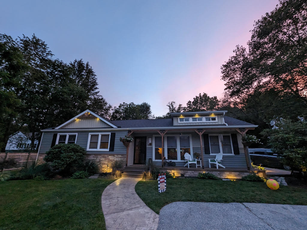 Wide view at sunset showing stamped concrete walkway and lighting