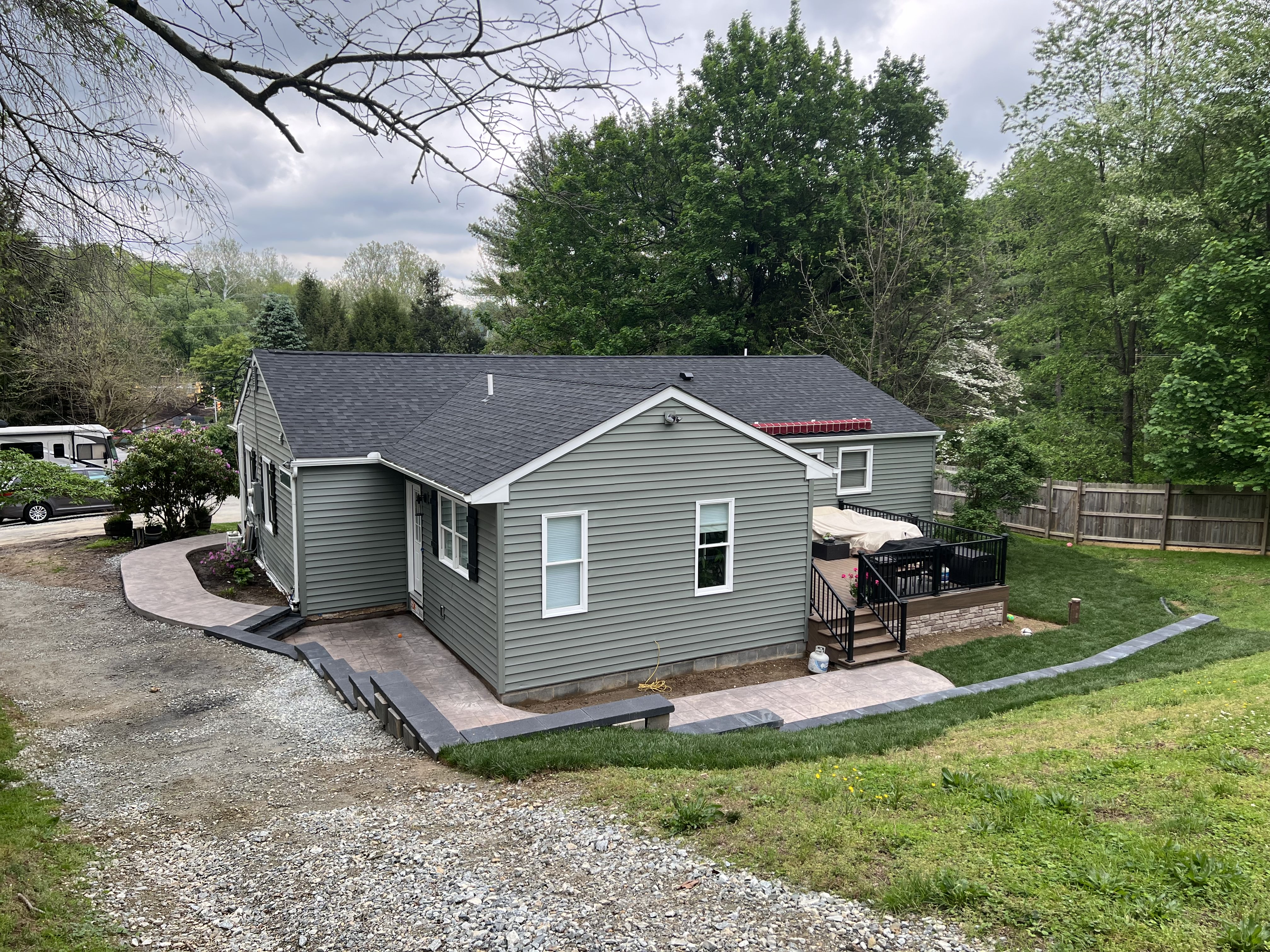 Aerial view of rear showing new roof, deck, and stamped concrete patio